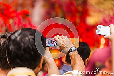 Man taking pictures on his phone performance artists. Chinese new year Editorial Stock Photo