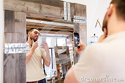 Man taking selfie by smartphone at barbershop Stock Photo