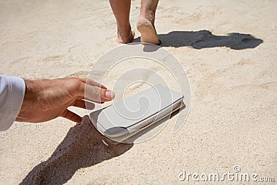 Man Taking Woman`s Lost Purse On Sand Stock Photo