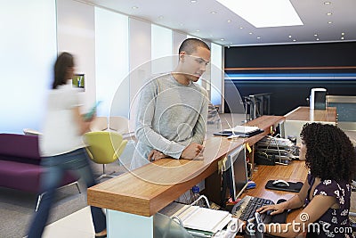 Man Talking To Receptionist At Office Stock Photo
