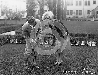 Man talking to woman while golfing Stock Photo