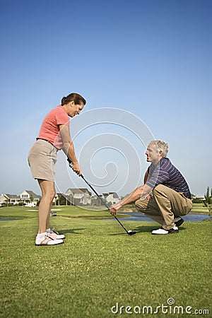 Man teaching woman golf Stock Photo