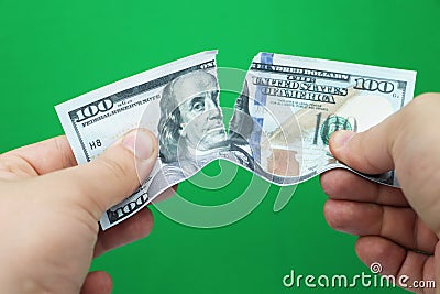 Man tearing dollars on green background Stock Photo