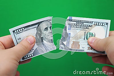 Man tearing dollars on green background Stock Photo