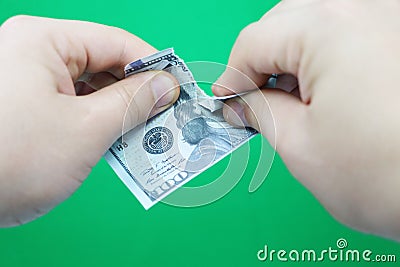 Man tearing dollars on green background Stock Photo