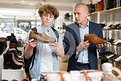 Man and teenage boy choosing dress shoes in shoe boutique Stock Photo