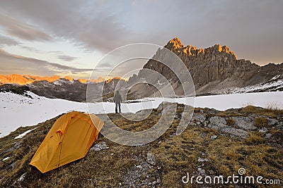 Man with tent observes the Alps Stock Photo