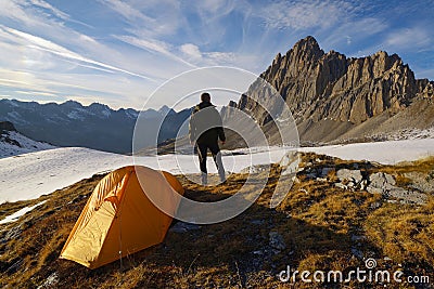 Man with tent observes the Alps Stock Photo