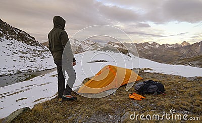 Man with tent observes the Alps Stock Photo