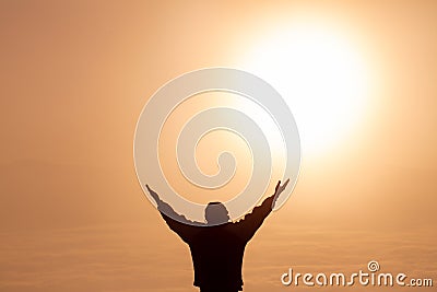 Man thank God on the mountain at sunrise in the morning,Praying for blessings from God in the morning Stock Photo