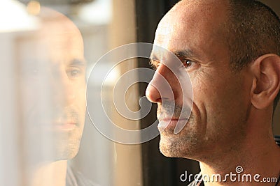 Man in thought with window reflection Stock Photo