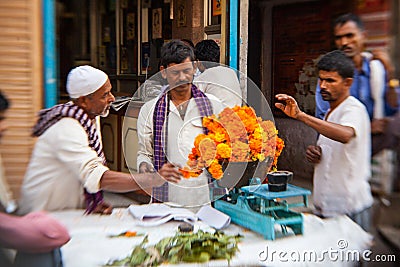Man threading colourful flower garlands in Delhi Editorial Stock Photo