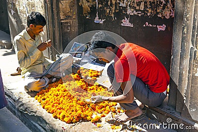 Man threading colourful flower Editorial Stock Photo