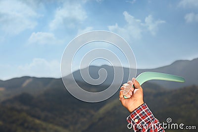 Man throwing boomerang in mountains, closeup. Space for text Stock Photo