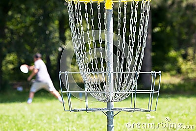 Man throwing frisbee playing disc golf in the park Stock Photo