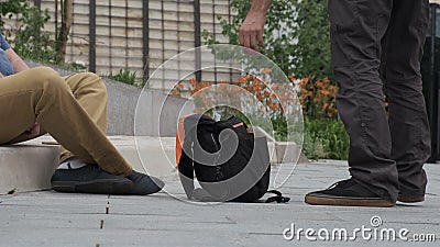 Man throws money into bag of beggar. Beggar, poor, lost tourist concept. Stock Photo