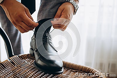 Man ties his shiney new black leather business shoes Stock Photo