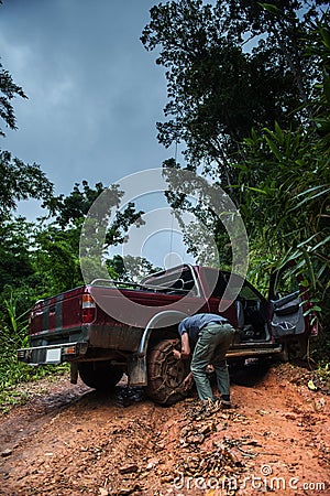 A man tighting the chain to the wheel for climbing the off road Stock Photo