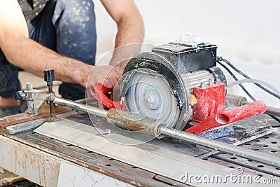 Man tiler construction worker electric porcelain cuts tiles Tile Stock Photo