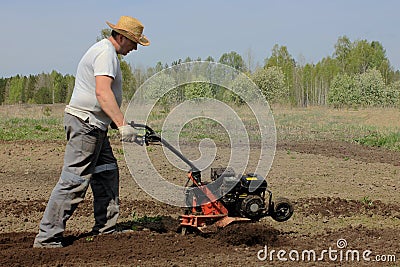 A man tilling ground with motor-cultivator Stock Photo
