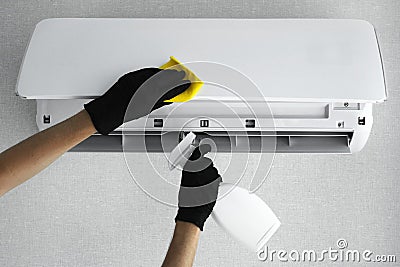 A man to clean the air conditioner at home with gloves with a special tool. cleaning company for cleaning. air conditioner cleanin Stock Photo