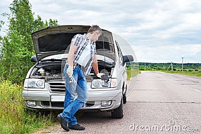 Man with tools waiting to help near broken car Stock Photo