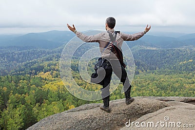 The man at top of the mountain enjoys beauty of the nature. To achieve the objectives Stock Photo