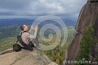 The man at top of the mountain enjoys beauty of the nature. To achieve the objectives Stock Photo