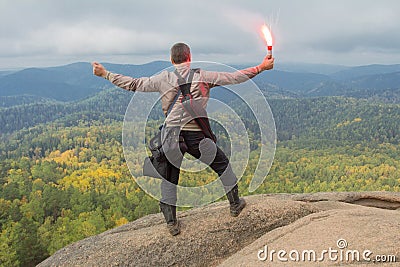 The man at top of the mountain enjoys beauty of the nature. To achieve the objectives Stock Photo