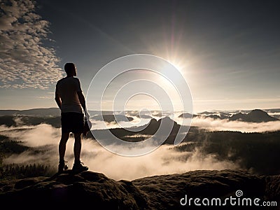 Man at the top of a mountain looking the misty landscape. Feel free Stock Photo