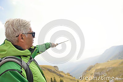 Man on top of the mountain pointing at something Stock Photo