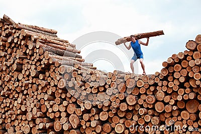 Man on top of pile of logs Stock Photo