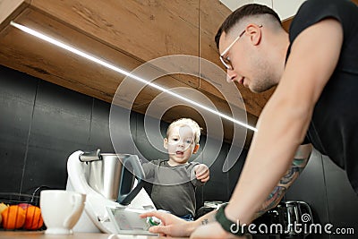 Man touch settings panel to turn on electronic blender. Little child help dad cooking dinner. Dissatisfied baby. Stock Photo