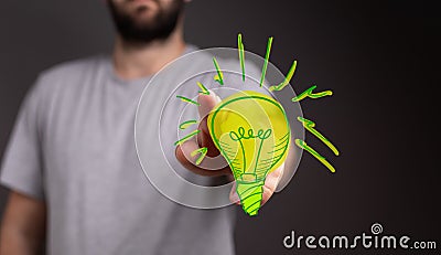 Man touching 3D rendered green light bulb icon with his two fingers Stock Photo