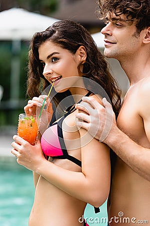 Man touching girl drinking cocktail through straw Stock Photo