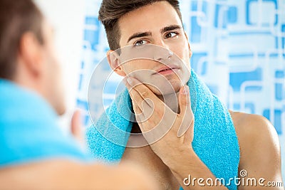 Man touching his face after shaving Stock Photo