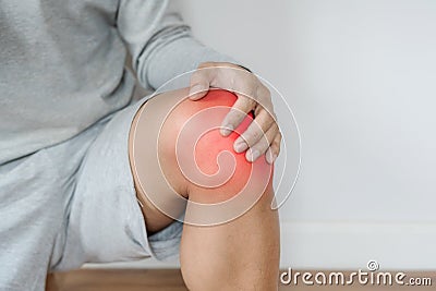 A man touching knee with red highlights concept of knee and joint pain Stock Photo