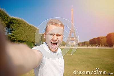 Man tourist Eiffel tower making selfie and smiling. Beautiful European guy enjoying vacation in Paris, France. Concept Stock Photo