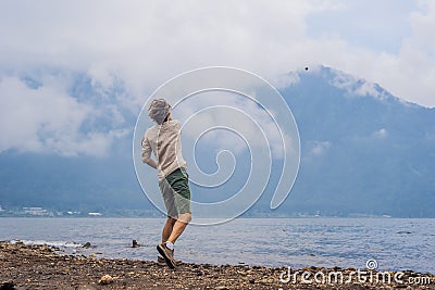 Man tourist at the lake Bratan and the mountains covered with clouds Stock Photo