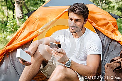 Man tourist using cell phone and portable mini speaker Stock Photo