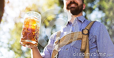 Man in traditional bavarian clothes holding mug of beer Stock Photo