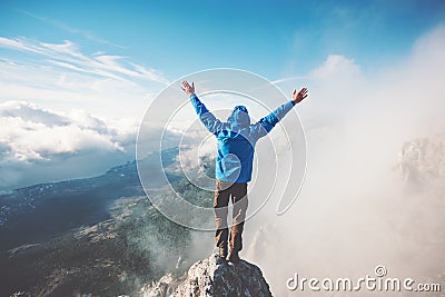 Man Traveler on mountain summit enjoying aerial view Stock Photo