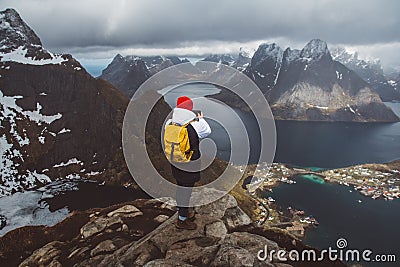 Man traveler taking photo with a smartphone hiking on Reinebringen mountain ridge in Norway lifestyle adventure traveling Stock Photo