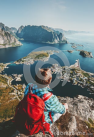 Man traveling in Norway sitting on cliff edge Stock Photo