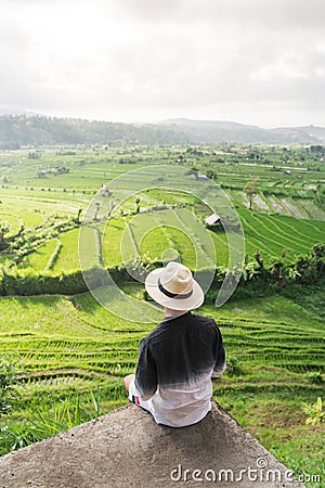 A man traveller sitting and looking to rice paddy in Bali island, Indonesia Editorial Stock Photo