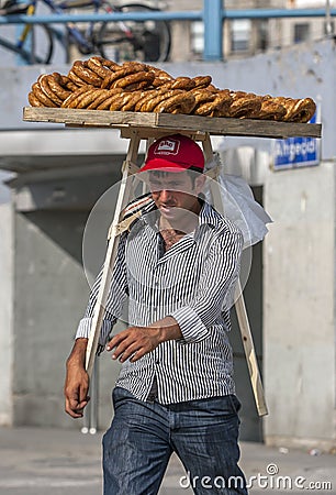 A man with a tray of fresh bread rolls for sale. Editorial Stock Photo