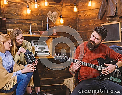 Man with trendy hipster beard composing song, music concept. Bearded man playing guitar. Family spending time listening Stock Photo