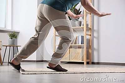 Man tripping over rug at home, closeup Stock Photo