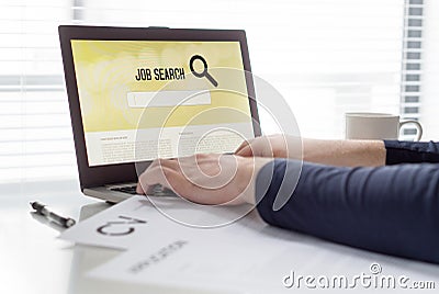 Man trying to find work with online job search engine on laptop. Jobseeker in home office. CV and application paper on table. Stock Photo