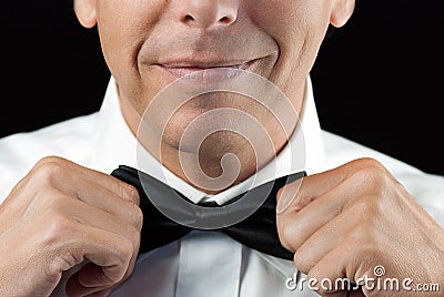 Man In Tux Straightens Bowtie, Two Hands Stock Photo